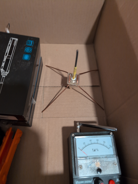 An antenna for US LoRa frequencies; there's a field strength meter and a soldering iron in the same box