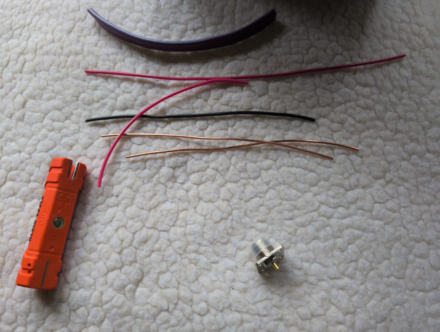 photo showing a piece of split Romex insulation, some insulated and stripped wire from inside the Romex, and an SO239 bulkhead connector