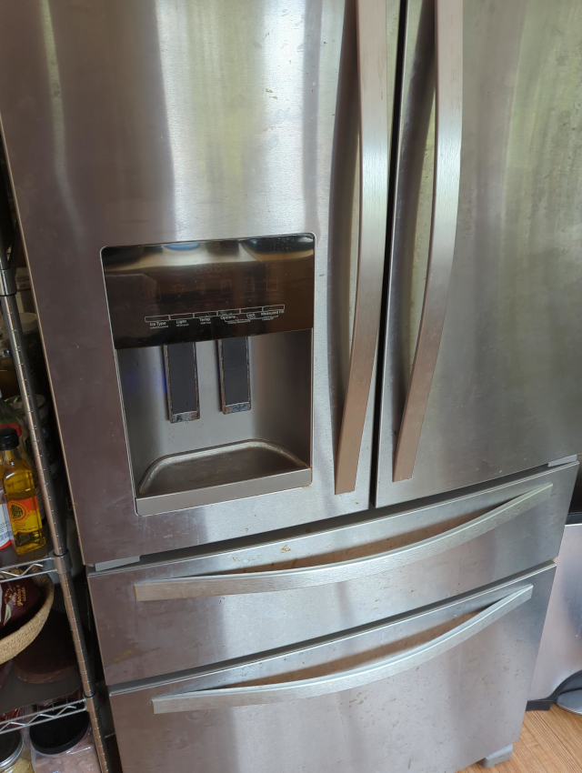 photo of the front of a stainless steel refrigerator with a water and ice dispenser in the door