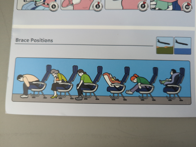 photo of the safety information card in the plane I took today, showing an illustration of folks demonstrating brace positions in aircraft seats that have MORE LEGROOM THAN ANY REAL AIRCRAFT