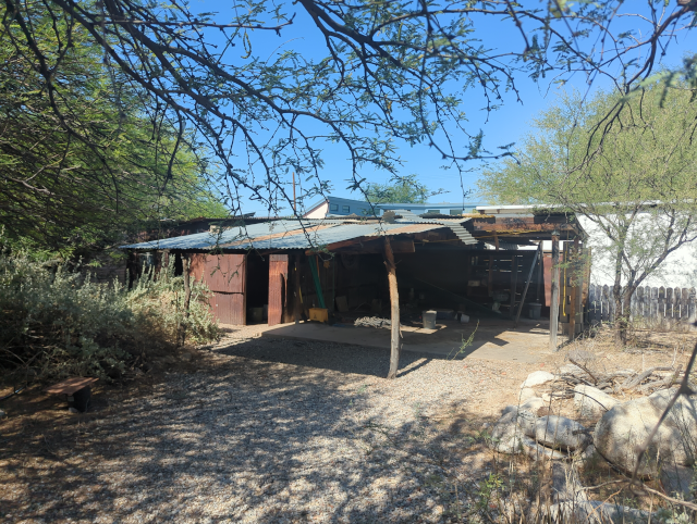 photo of an old shed with a tin roof in a desert backyard