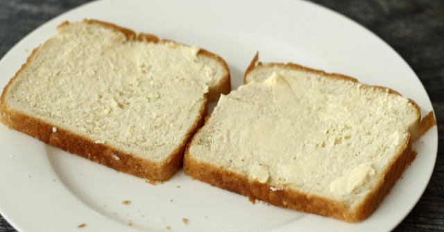 picture of two slices of white bread smeared with butter