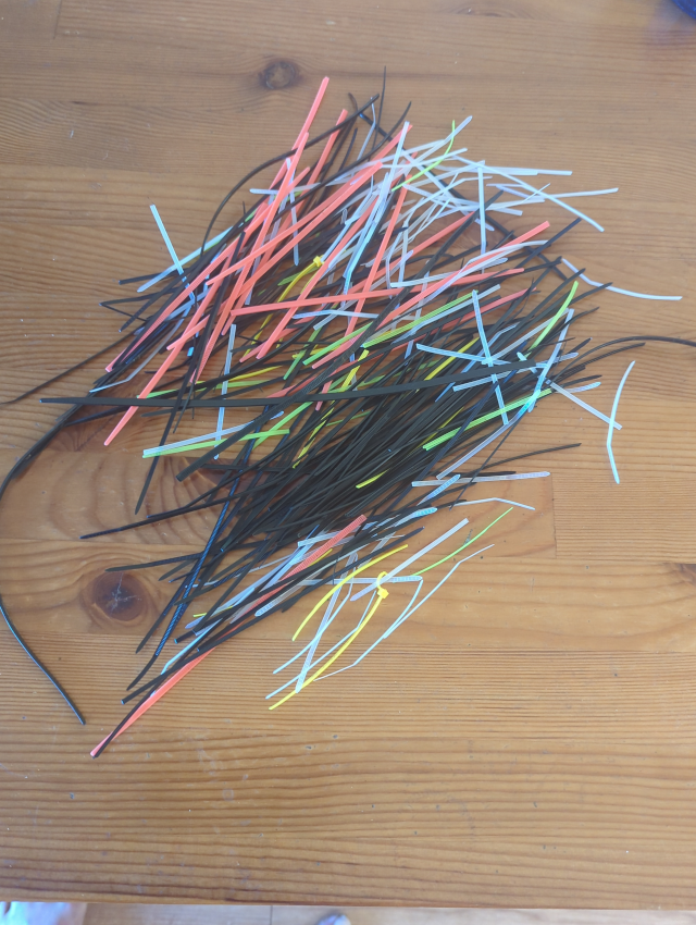 photograph showing a pile of multicolored tails clipped from wire ties