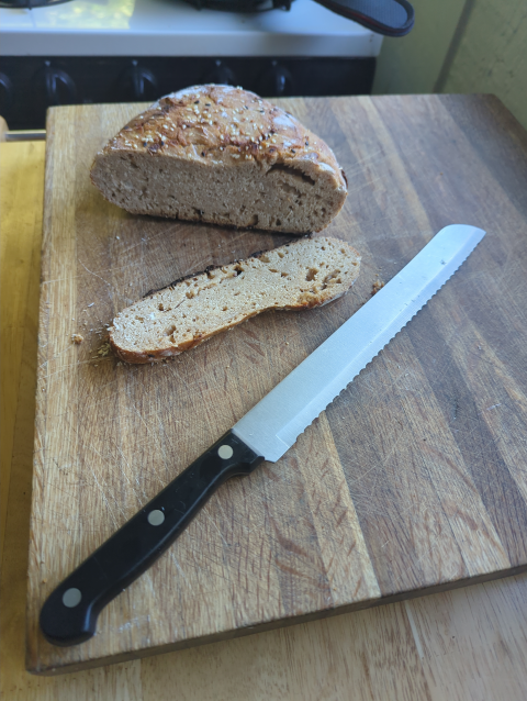 photo of a dense loaf of bread, with a slice cut off