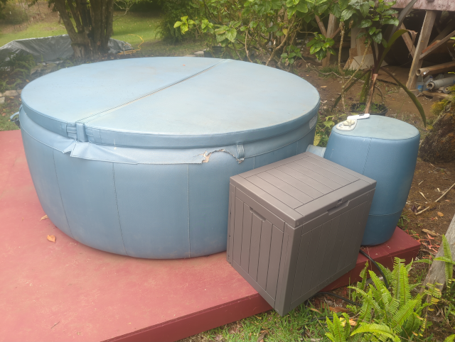 photo of a blue hot tub with a brown plastic deck box next to it
