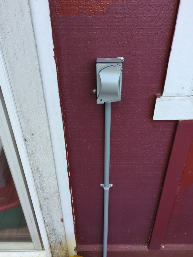 photograph of an outdoor outlet with conduit leading down to the deck floor