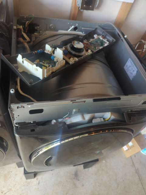 photo of a disassembled dryer showing multiple detached circuit boards atop it