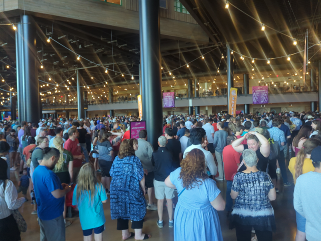 photo of a vast, high-ceilinged room filled with people