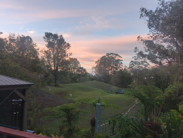 photo from our back deck with the sun setting and coloring some wispy clouds