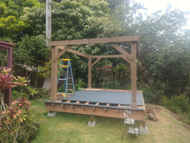 photo of the pavilion with two walls erected and connected by long beams