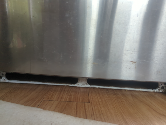 photo of the space under our refrigerator where you're supposed to clean the condenser coils