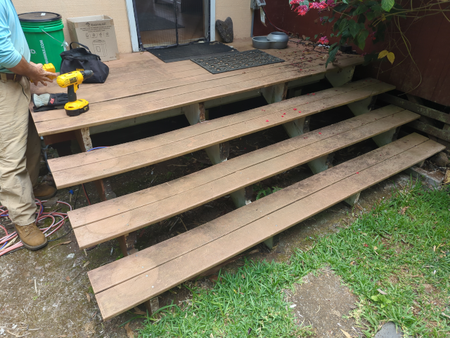 photo of the front steps with the rotting risers removed, revealing a sound substructure but with stringers placed far too far apart for the type of decking material used