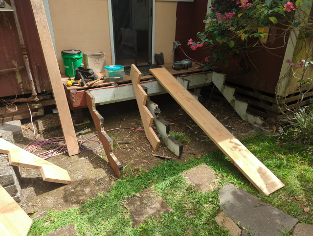 photo of the front steps with the newly-cut stringers lying about (and a spare 2x12 serving as a ramp)