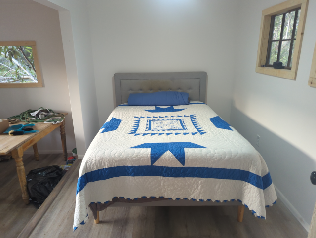 photo of a full bed in the studio, made up and ready for snoozing