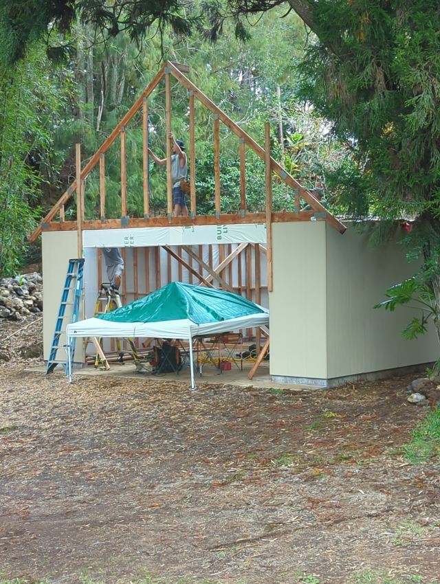 photograph of a garage under construction with a single roof truss installed