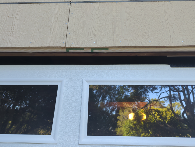 photo of the top of the garage door, showing the gap that is partially filled by brushes on the far right