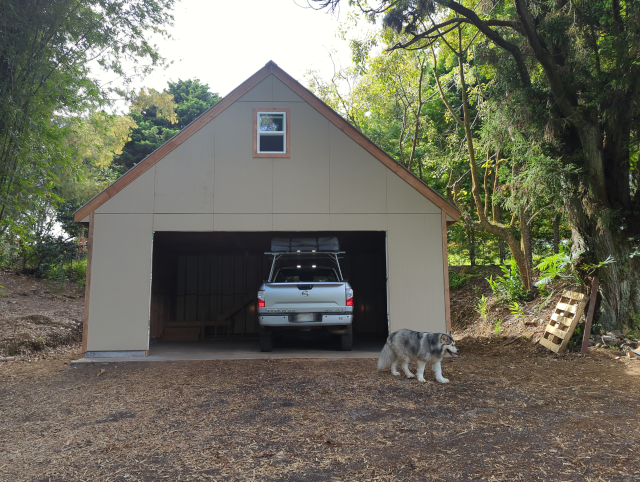 photograph of the new garage, without a garage door but housing Timmy the Titan complete with a tent-on-top camper