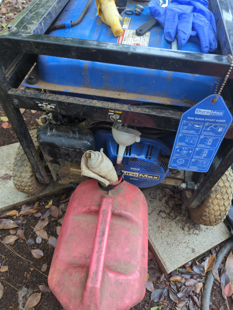 photo showing the generator's gas tank being drained into a gas can
