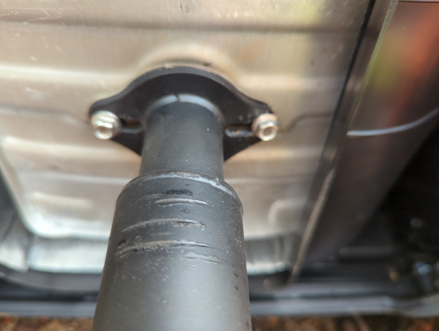 photo showing the generator's exhaust port, with the factory spark arrestor removed and an adapter for the aftermarket exhaust system in place