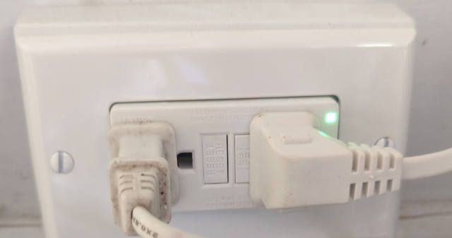 photo of a GFCI-equipped electrical outlet showing a glowing pilot light