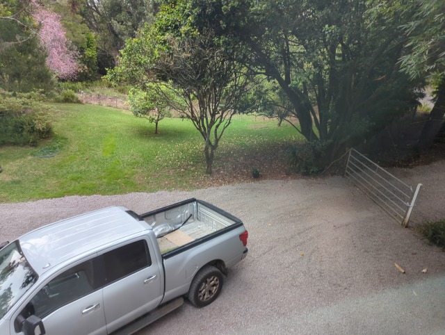 photo of our freshly-graveled drive with Timmy the Titan and Joulee the Free Salvage Tesla parked on the new rock