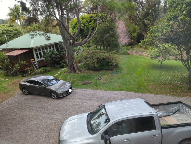 photo of our freshly-graveled drive with Timmy the Titan and Joulee the Free Salvage Tesla parked on the new rock