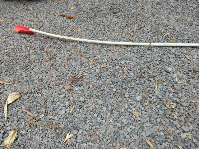 photo of a red plastic gutter scoop attached to a length of PVC pipe