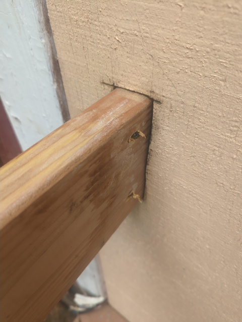 photo of the horizontal part of the handrail joined to the house with a mortise and some toenail screws