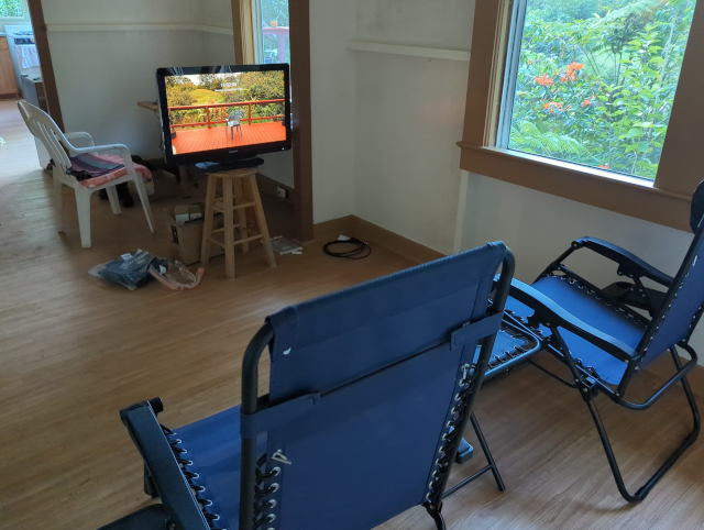 a photo of a "home theatre" consisting of two folding lounge chairs and an old television on a barstool