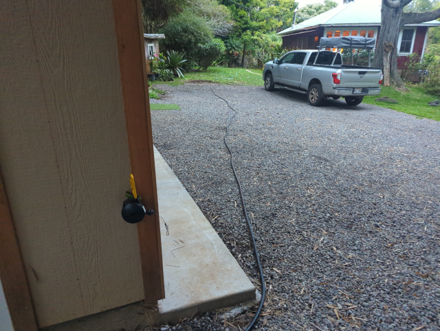 photo of a hose running from the garage, through the coupler, and to a spigot on the house