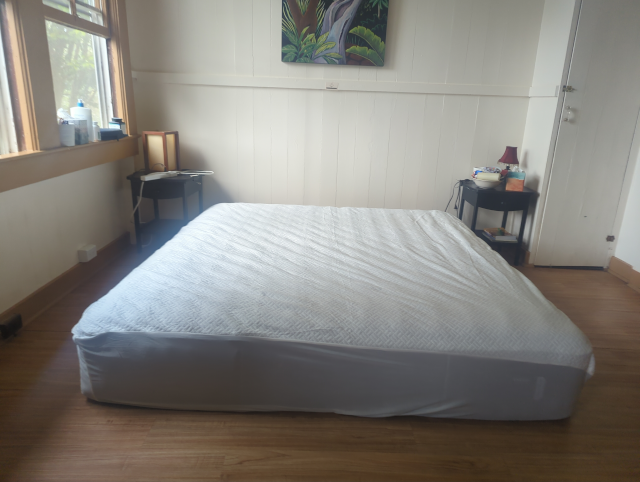 photo of the bedroom with a king-size mattress in it, on the floor