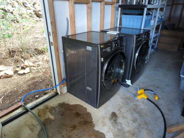 photo of a washer and dryer connected to a garden hose and extension cord