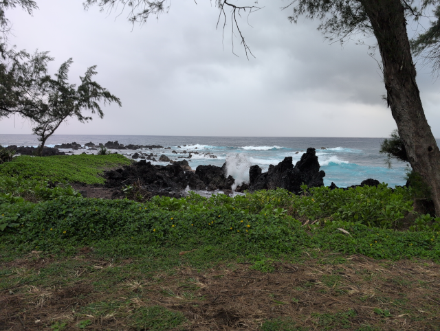 photo showing a wave breaking against shore rocks
