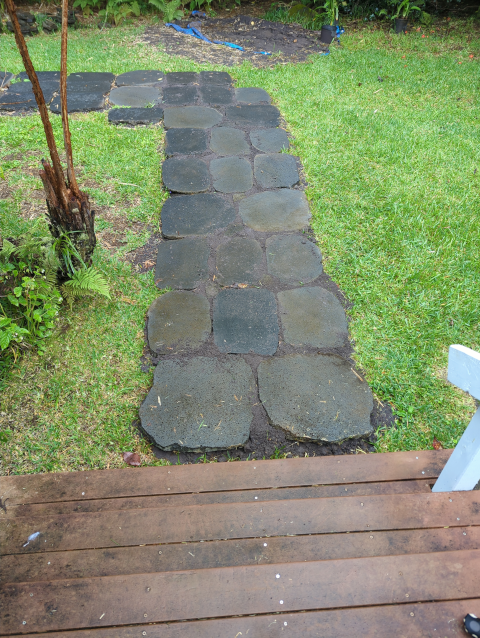 photo showing the short leg of the front path; now the stones have been leveled and the spaces between them filled with sand