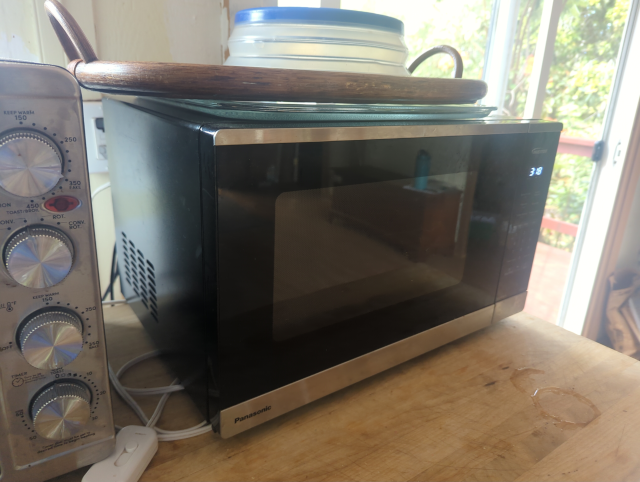 photo of a Panasonic microwave oven, door closed, display showing the time "3:18"