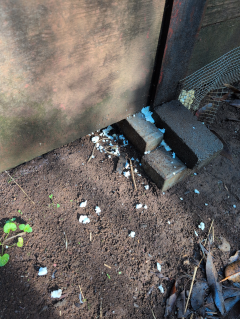 photo showing the pier under a post of the barn, with bits of structural foam scattered around it