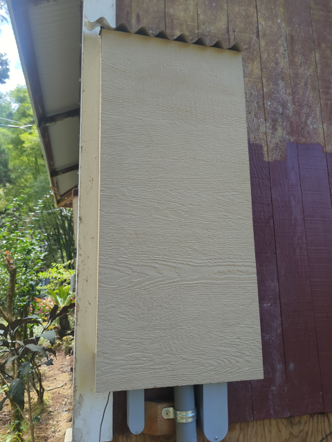 photo of the electrical panel cover showing a corrugated metal roof installed over the top