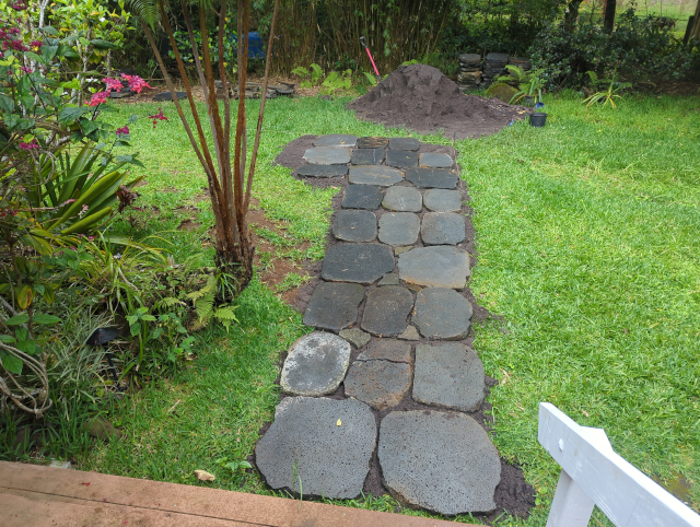photo looking down from the front steps; the path is now complete to where it turns toward the driveway; everything is getting wet