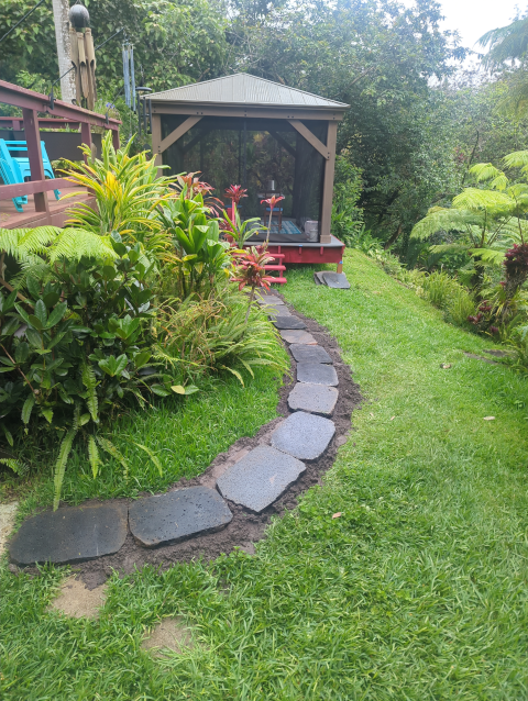 photo showing a new path made from a single width of lava rock pavers from the bottom of the deck stairs to the pavilion