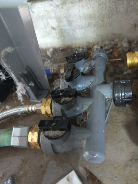 photo of a quadruple garden hose manifold covered with dryer lint