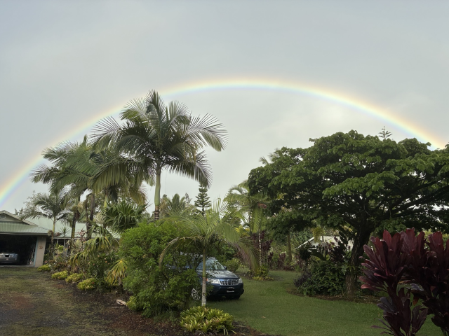 photo showing a dramatic full-arc rainbow above Queen B's house