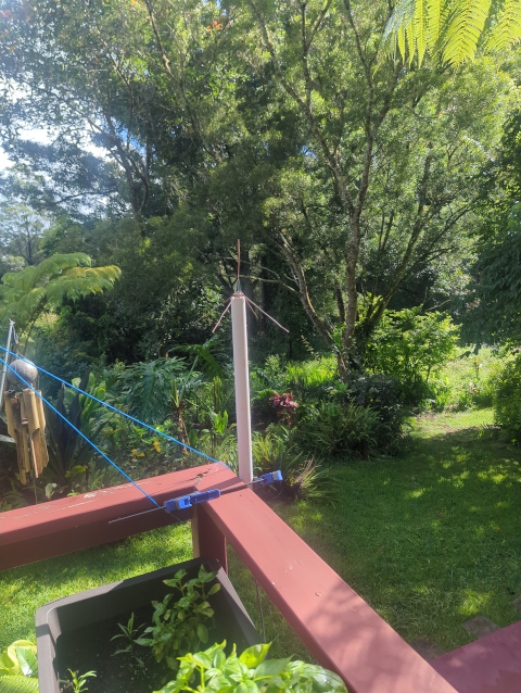 photo of a small antenna consisting of a vertical copper wire and four sloping ground-plane wires soldered to a PL-259 connector mounted on a length of PVC pipe