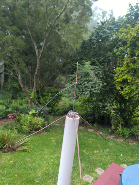 photo of my ¼ wave vertical antenna with a wire clipped to it and hanging off about halfway along the vertical element