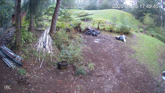 screen grab from a security camera showing plumbing supplies and a solar panel array in a wet pasture