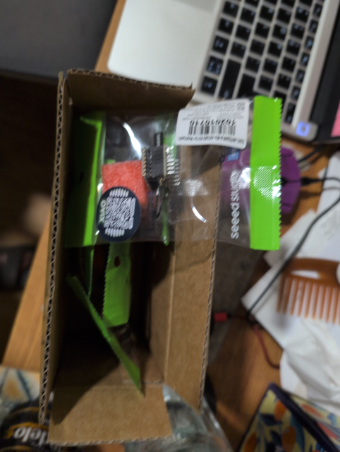 photo showing a cardboard box filled with plastic envelopes; one envelope is lying on top showing a seeed mesh node