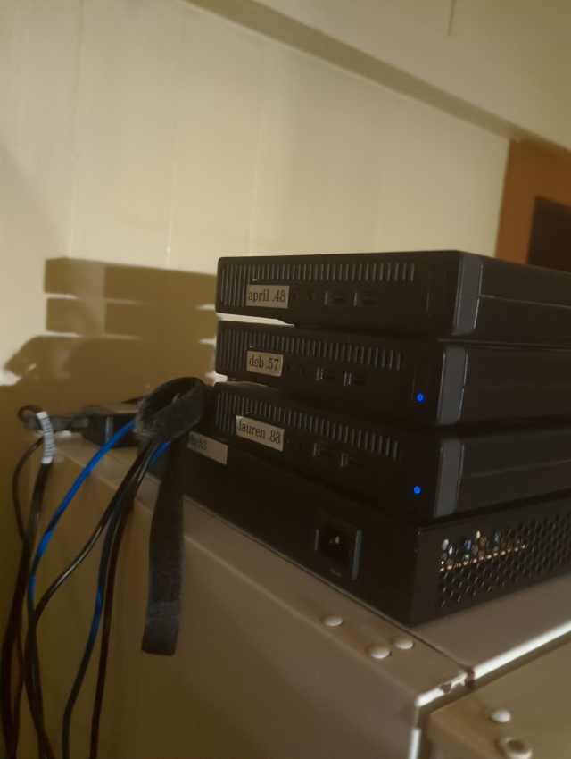 photograph of three mini-HP servers sitting on top of a 24-port switch