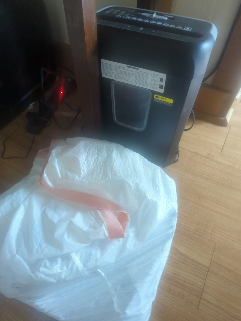photo of my small bonsaii paper shredder with a white plastic bag of to-be-shredded papers in the foreground