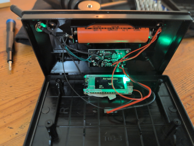photo showing the open solar spotlight case with a T114 with the Meshtastic logo on its TFT display