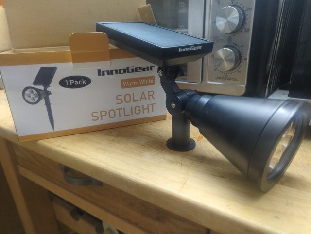 photo of a solar powered garden spotlight in front of its box