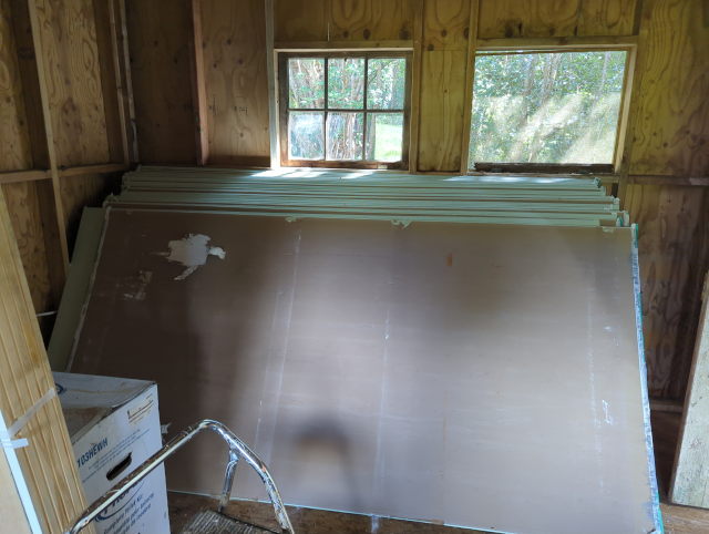 photo of drywall sheets stacked against an indoor wall